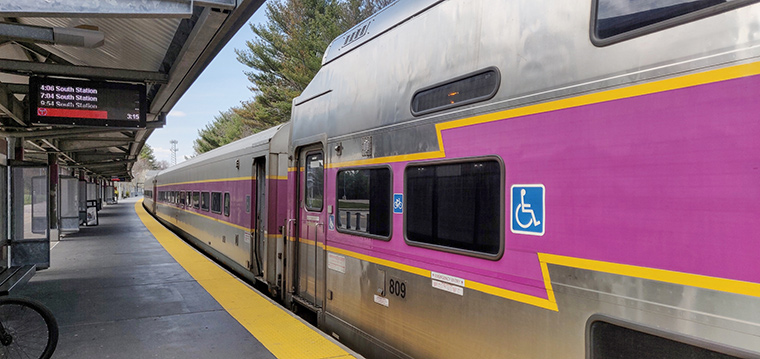 Photograph of Lowell Commuter Rail Station platform with a departing train.